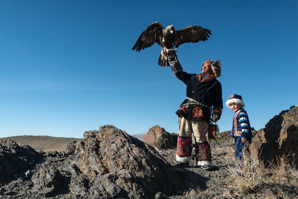 Hombre nativo americano de pie sosteniendo un águila
